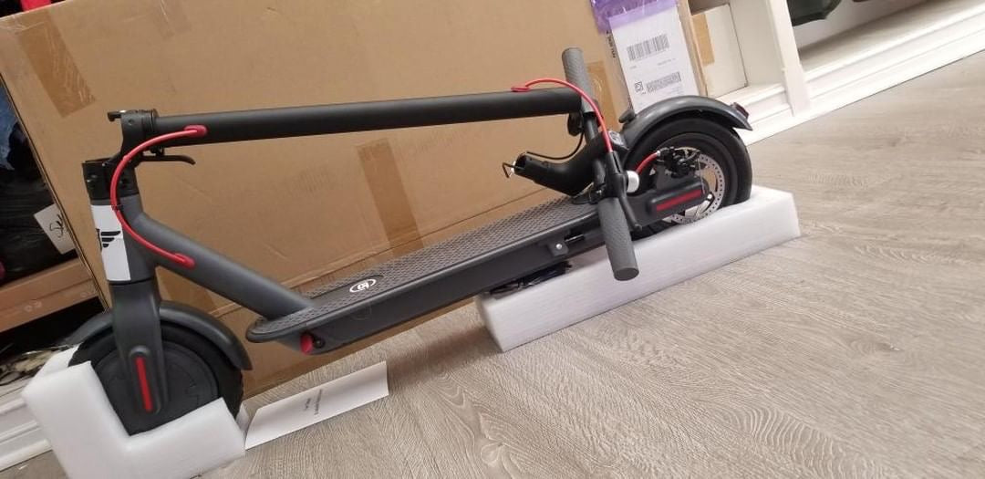 A boxed Simply Brilliant scooter shown fresh out of packaging indoors