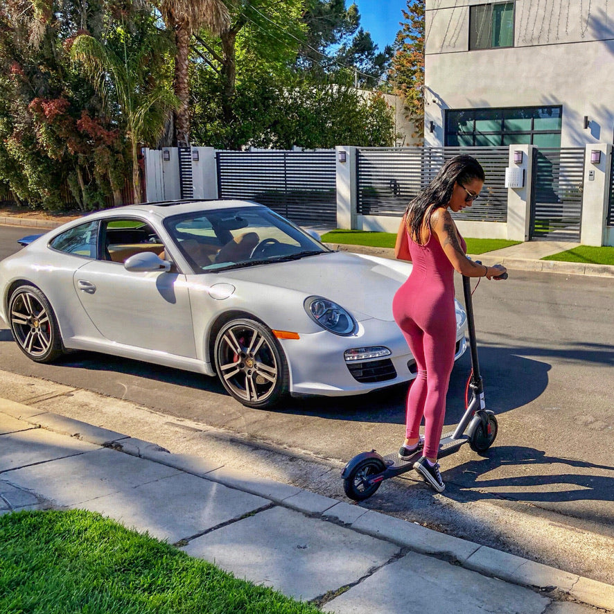 A rider next to a silver Porsche with a Simply Brilliant scooter