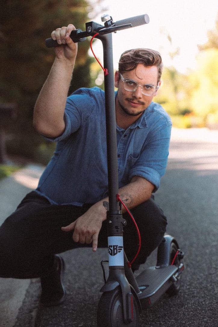 A close portrait of a rider posing with a Simply Brilliant scooter